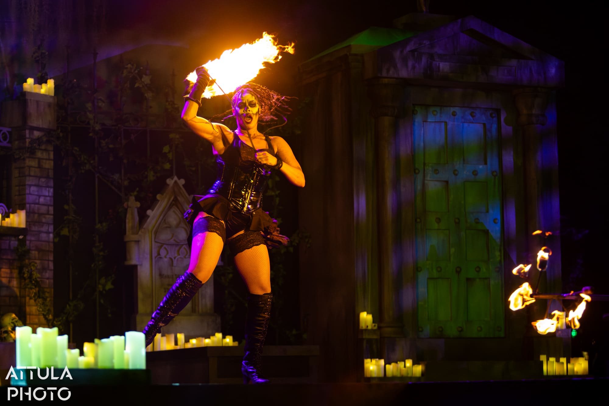 Maman Brigitte swings an arc of live flame over her head before the mausoleum — Voodoo: Bayou's Edge, Knott's Scary Farm 2026
