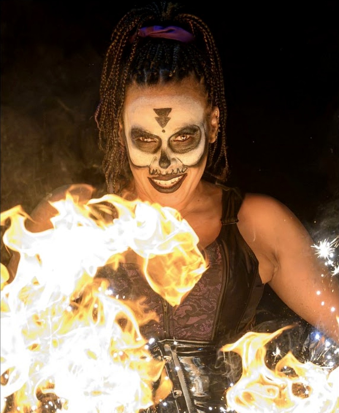Tiana Powell as Maman Brigitte grins over the flaming barrels — Voodoo: Bayou's Edge, Knott's Scary Farm 2026