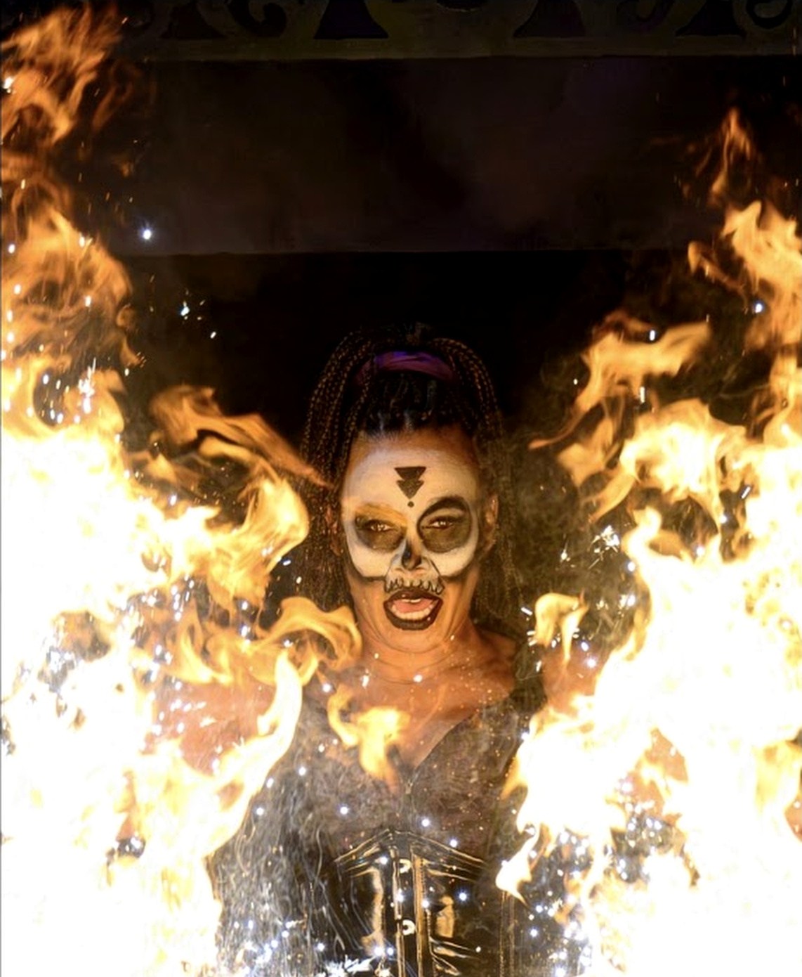 Tiana Powell as Maman Brigitte, framed by walls of flame — Voodoo: Bayou's Edge, Knott's Scary Farm 2026