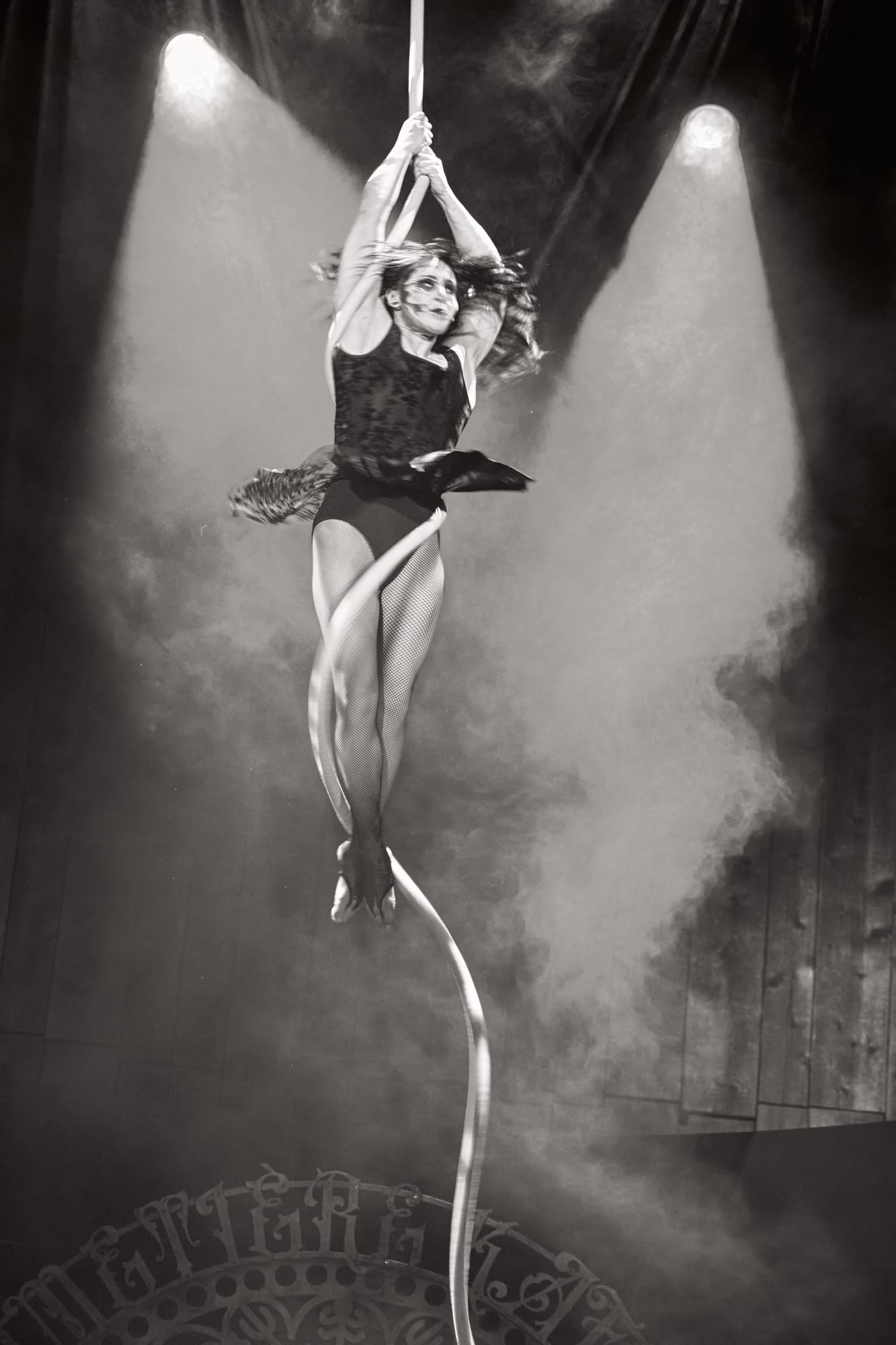 Storm Hovan, the aerialist, spins high on the rope through the haze — Voodoo: Bayou's Edge, Knott's Scary Farm 2026