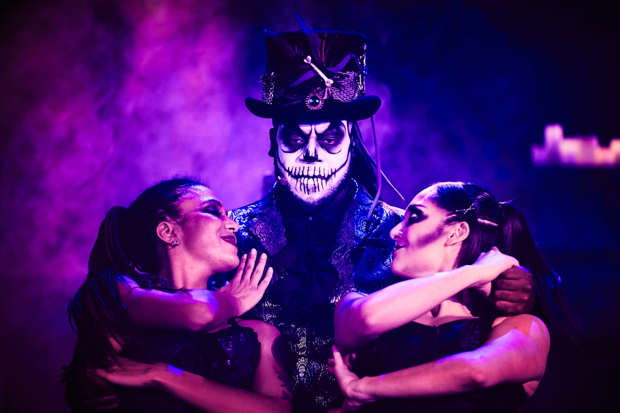 Dedrick Bonner as Baron Samedi stares out as two of the Gede wrap around him — Voodoo: Bayou's Edge, Knott's Scary Farm 2026